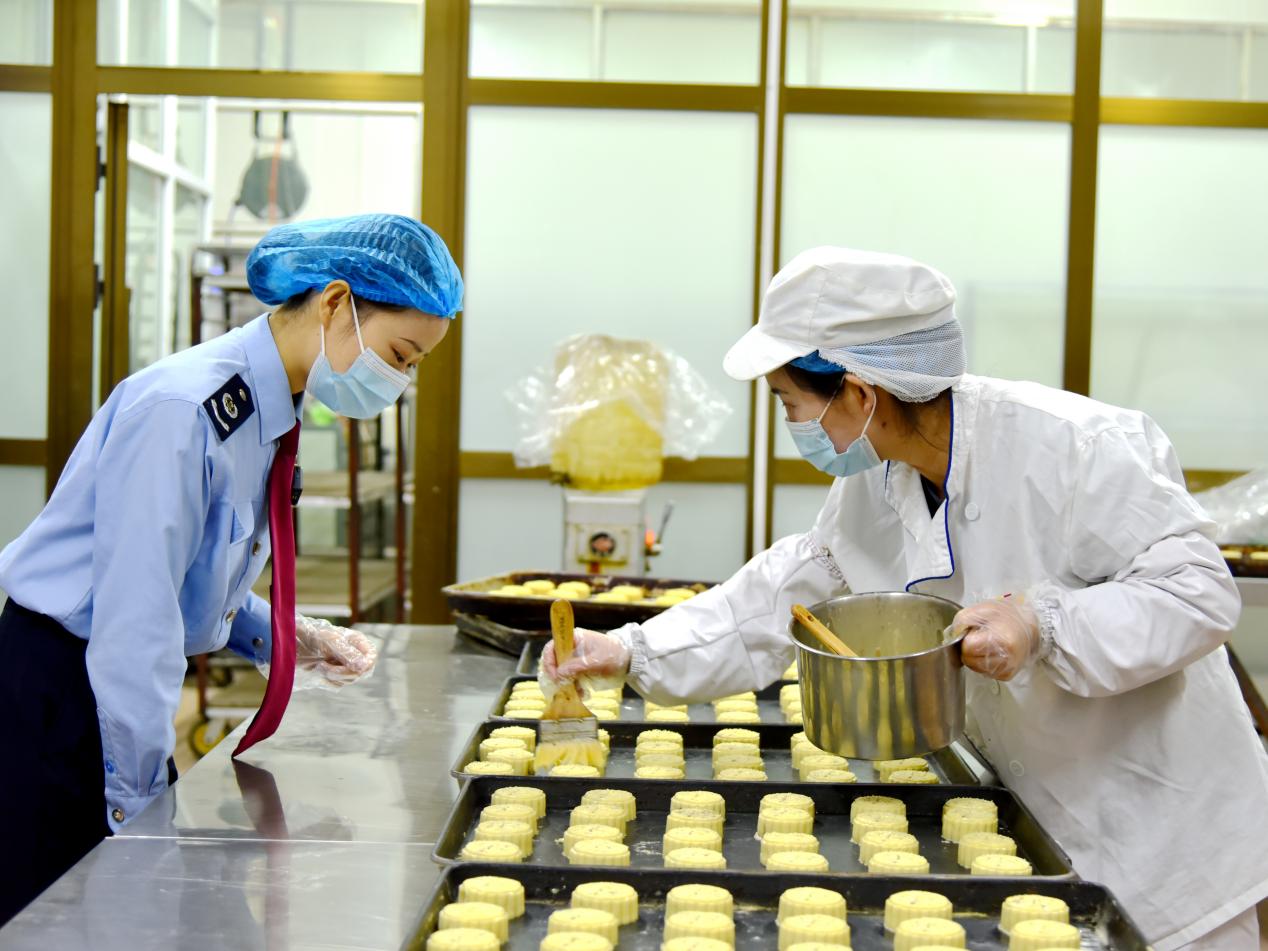 稅務(wù)干部走進(jìn)月餅加工廠了解月餅生產(chǎn)過程。關(guān)卻吉攝