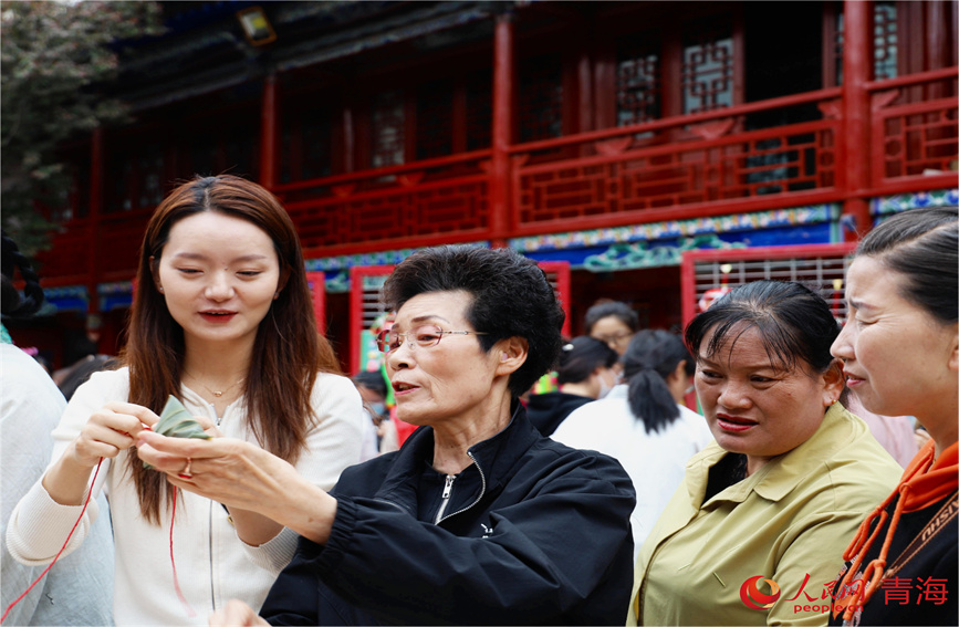 市民學(xué)習(xí)包粽子。人民網(wǎng) 顧斐菲攝