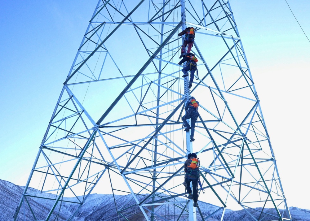 2024年12月20日，國網(wǎng)青海省電力公司施工人員身背氧氣罐登塔開展果洛第二回330千伏線路工程組塔作業(yè)。鄒建華 攝