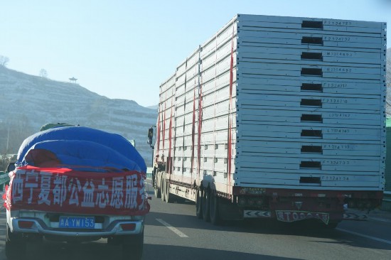 12月24日，行駛在前往青海省海東市民和縣的高速公路上的支援物資車。人民網(wǎng)記者 甘海瓊攝