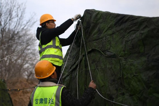 12月20日，甘肅省臨夏州積石山縣大河家鎮(zhèn)大河村集中安置點(diǎn)，工作人員在布設(shè)無線網(wǎng)絡(luò)。人民網(wǎng)記者 翁奇羽攝